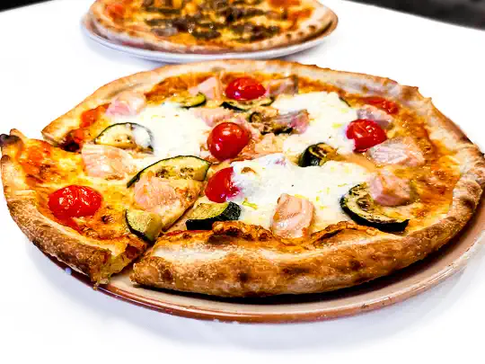 Pizza Carretto mit Tomaten, Mozzarella, Kirschtomaten, gegrillte Zucchini, Burrata und Lachs
